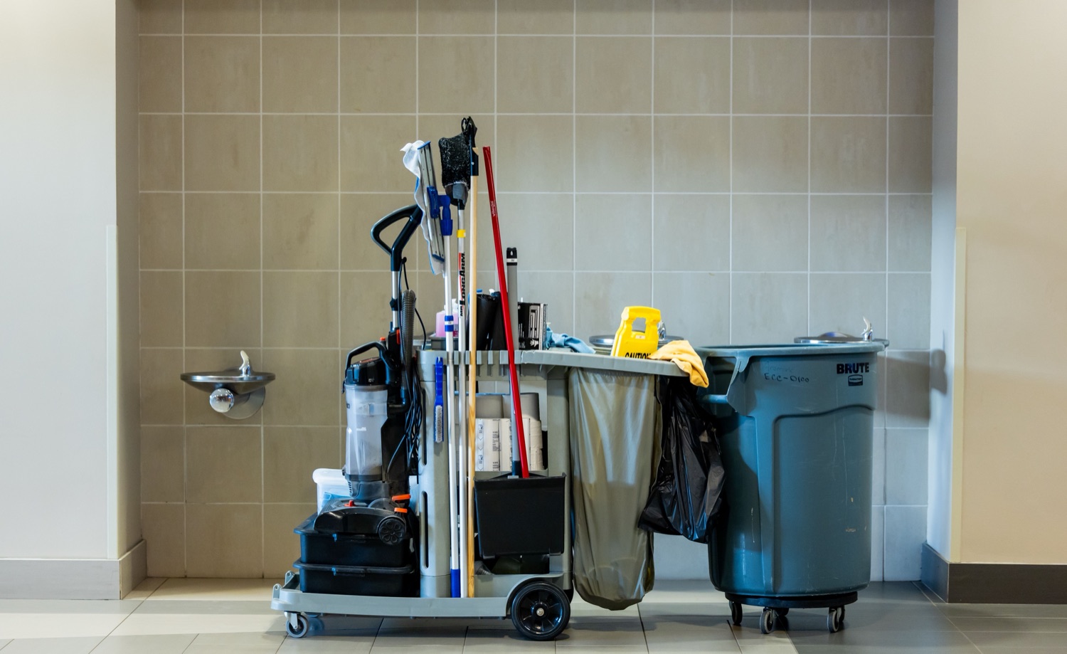 Janitorial cart and floor scrubber in a commercial hallway